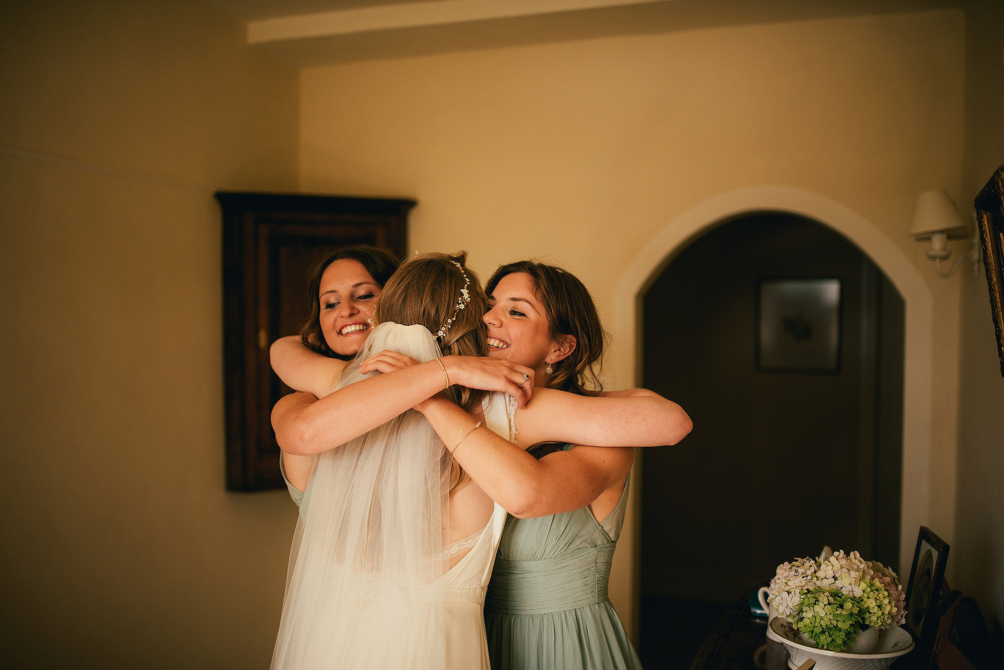 bridesmaids hugging bride