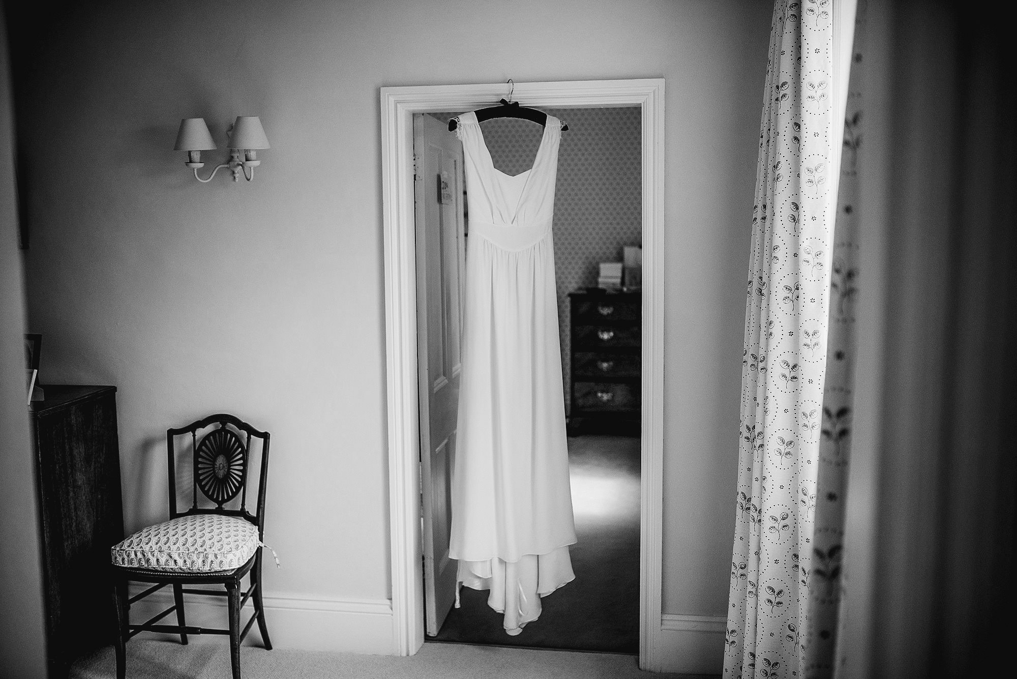 wedding dress hanging in door way